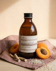Evera Shampoo No 2 Moisturising with halved apricots on dusty-rose linen, warm ivory-peach backdrop