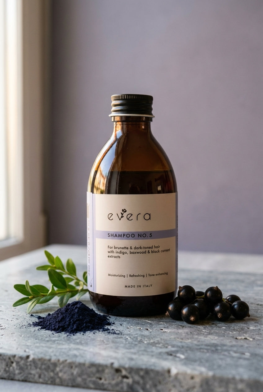 Evera Shampoo No 5 Brunette with indigo powder and boxwood sprig on grey travertine, dusty lavender backdrop