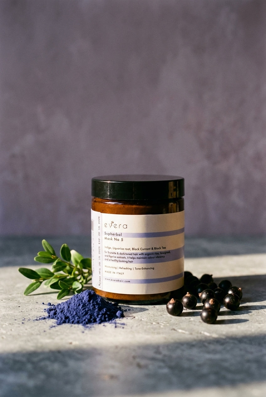 Evera Mask No 5 Supherbal Brunette with indigo powder and boxwood on grey travertine, dusty lavender backdrop
